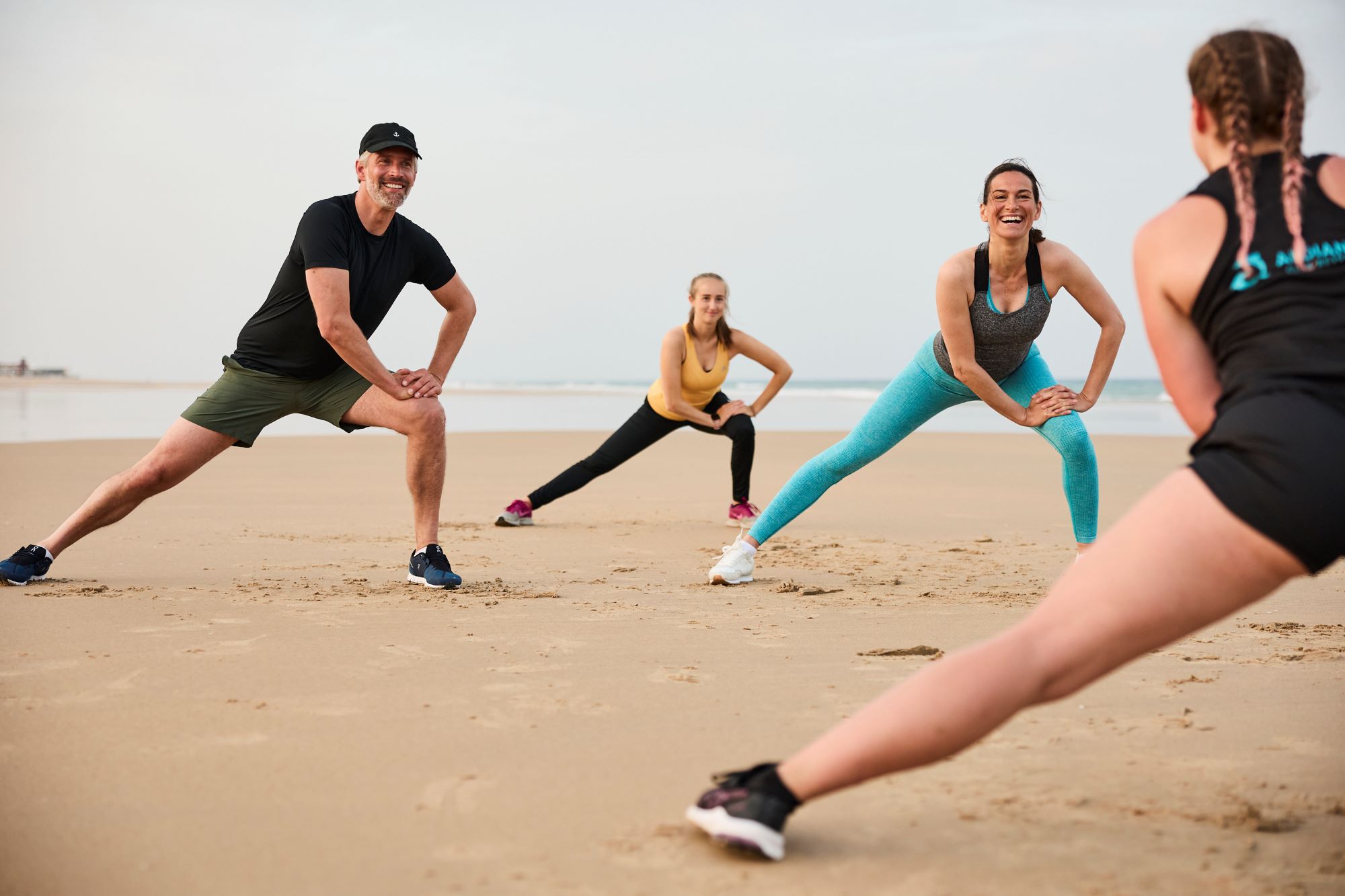 Frauen und Männer am Strand beim Sport in einer Clubanlage