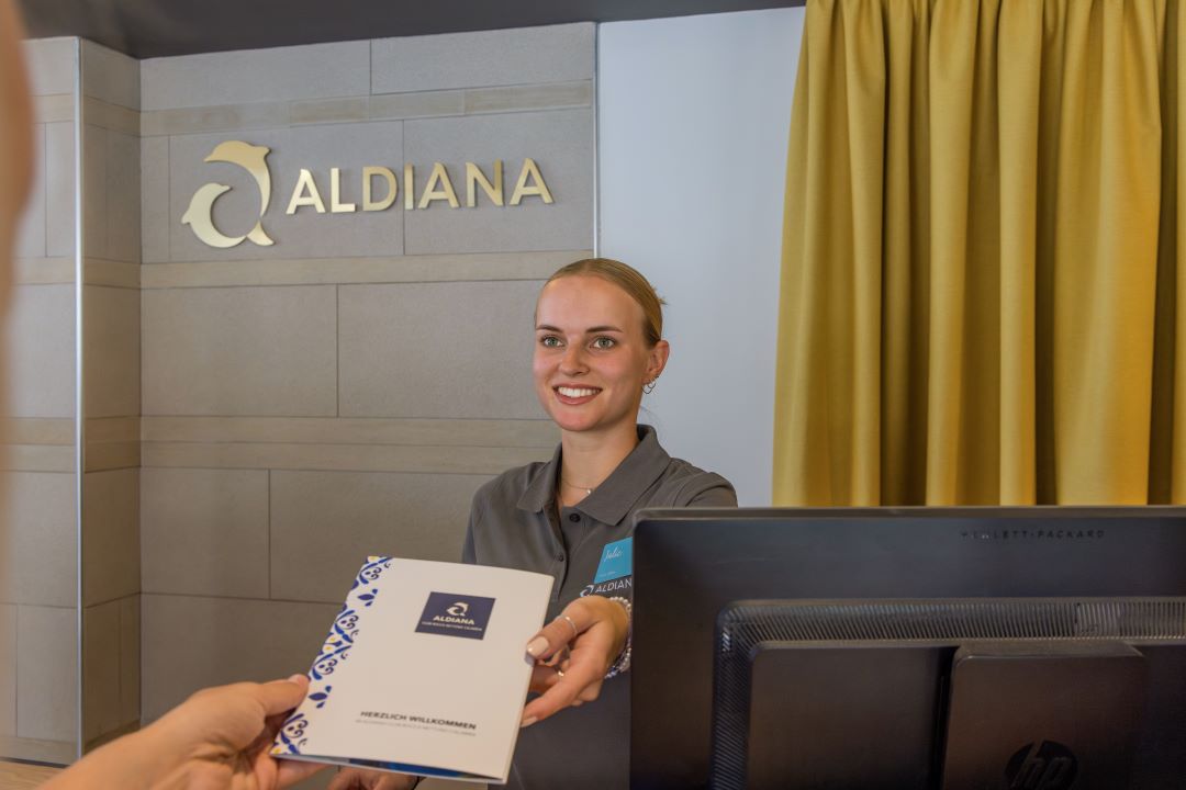 Junge Frau an Rezeption, Job im Hotel, Empfang im Hotel